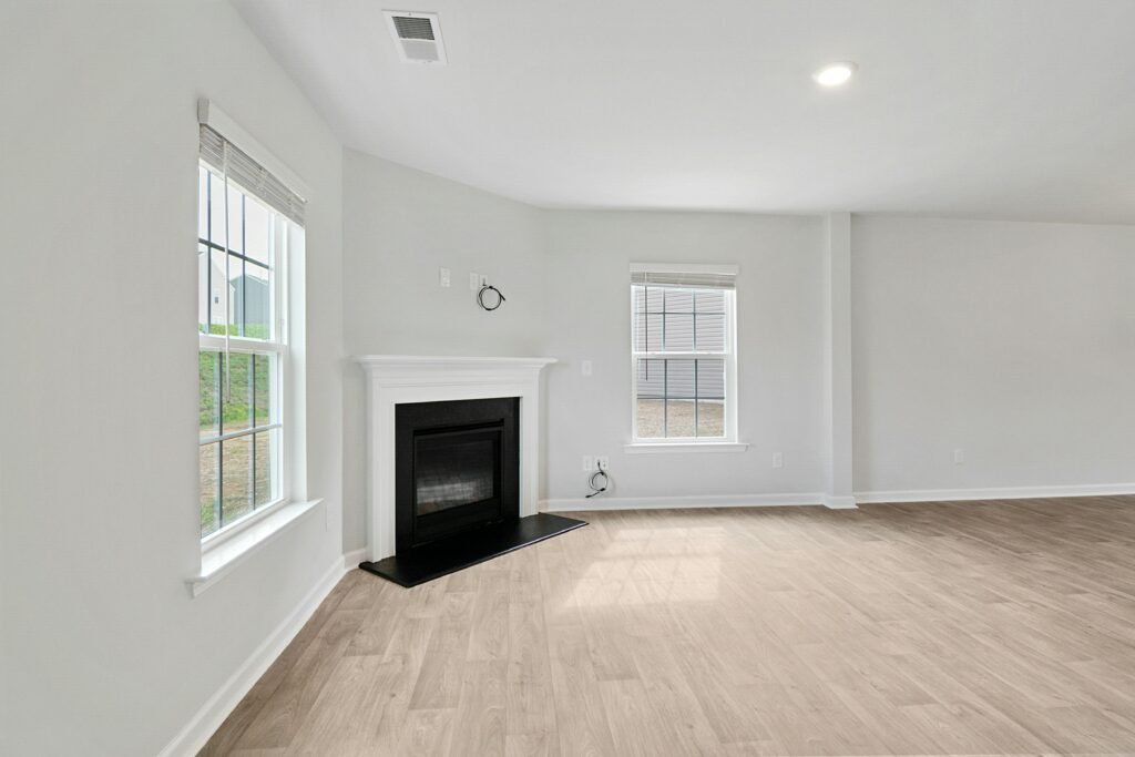 Spacious modern living room featuring a fireplace and natural light through large windows.