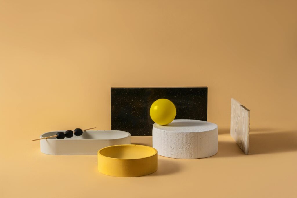 A studio shot of a creative minimalistic geometric composition featuring various shapes and colors on a yellow background.